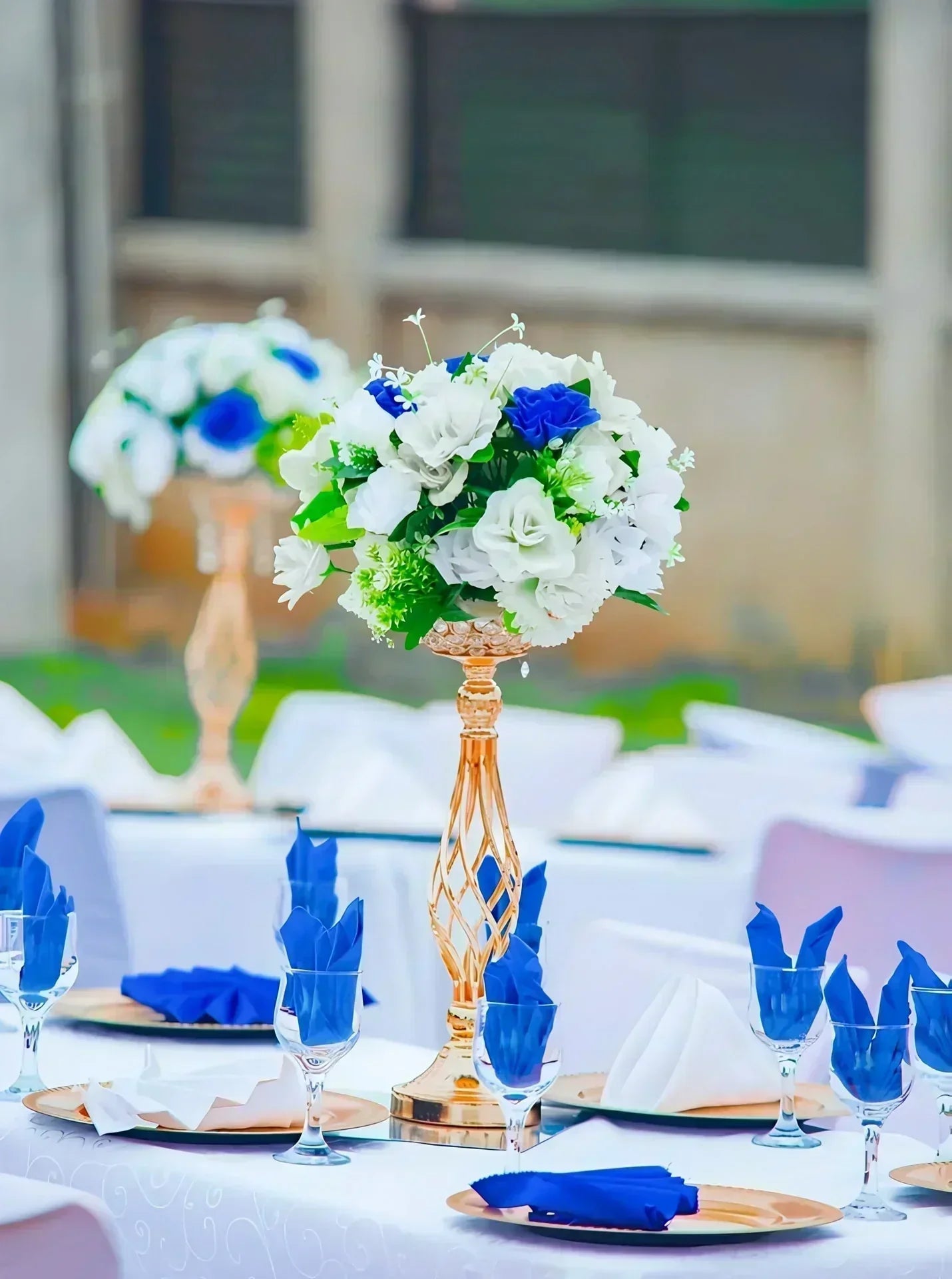 Présentation d'un vase bougeoir doré au centre d'une table de mariage.