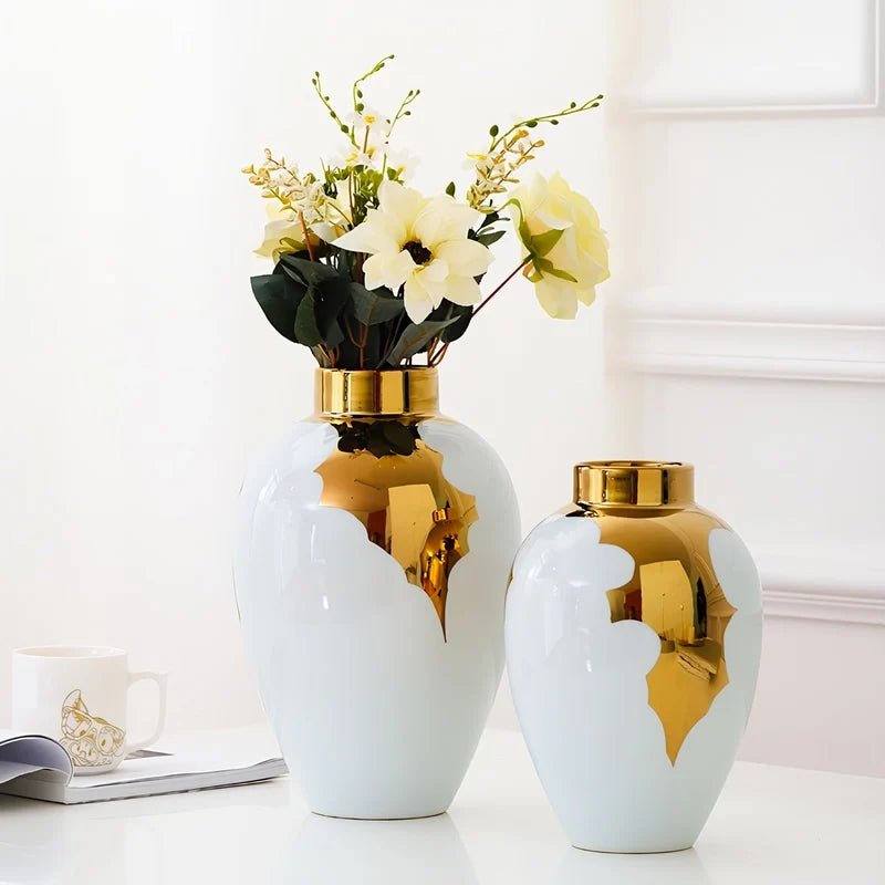 Présentation de deux vases luxueux blanc et doré avec bouquet de fleurs blanches