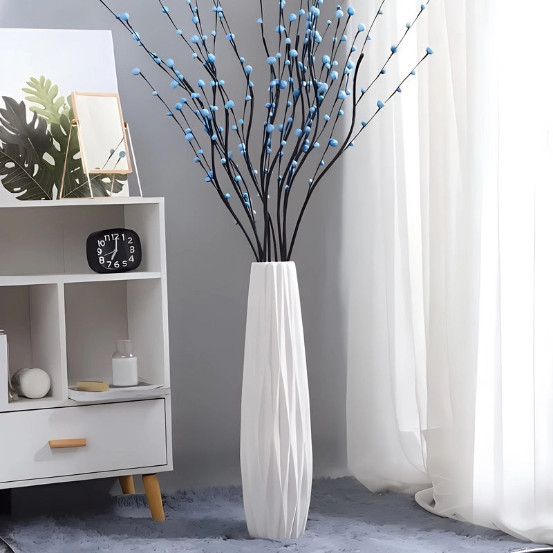 Grand Vase Original Blanc Origami 45cm, présentation posé au sol avec bouquet de fleurs bleues.