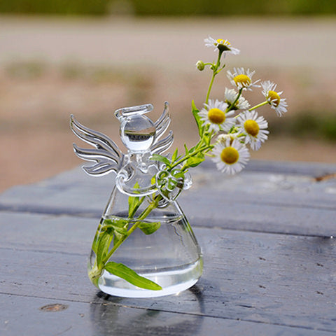 Soliflore Ange transparent en Verre présentation avec marguerites sur une table en bois.
