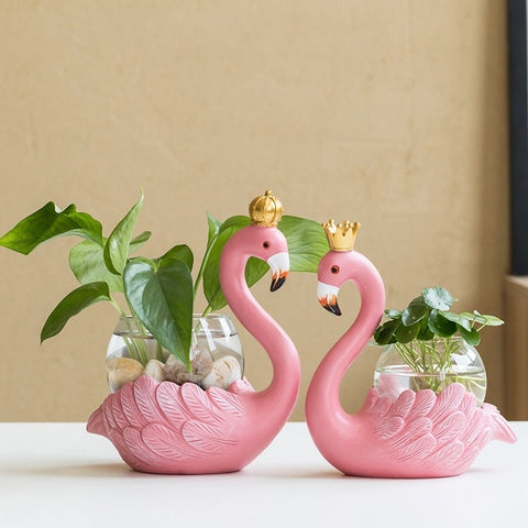 Soliflore Flamant rose couronné en Verre et Résine présentation des modèles Grand 1 et 2 avec plantes vertes.