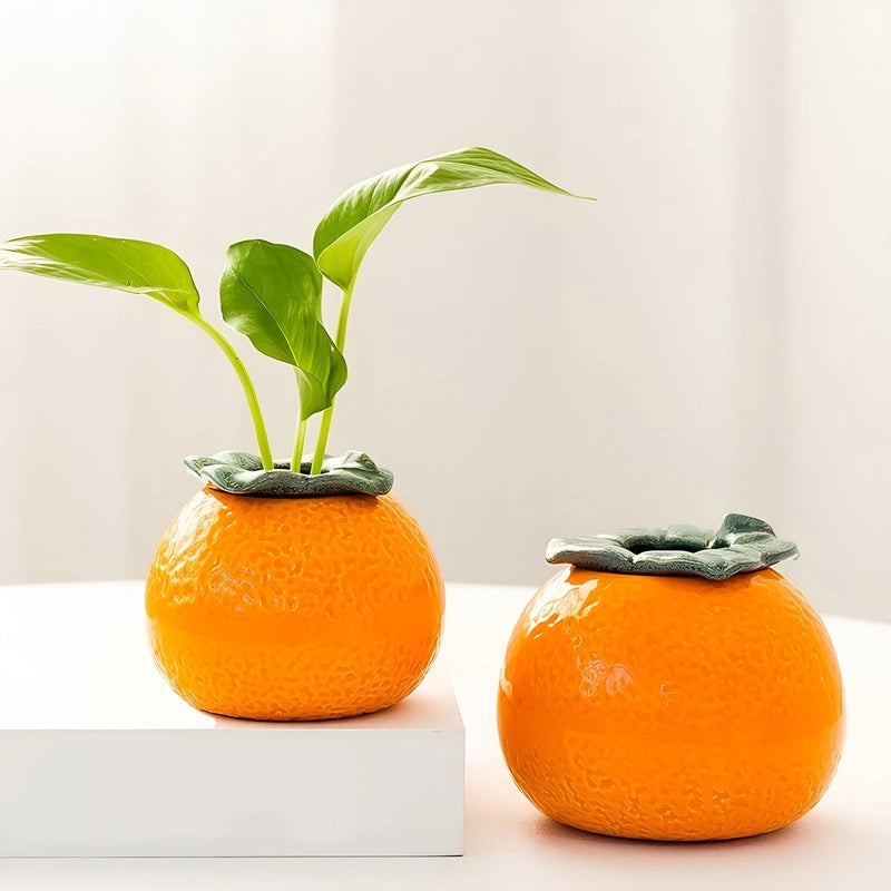 Soliflore en Forme d'Orange en céramique présentation des modèles S avec plante verte et L sans plante sur une table blanche.