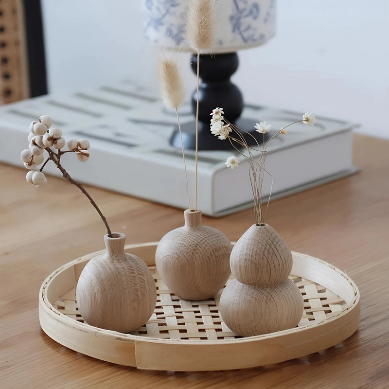 Soliflore Gourde Wu Lou en Bois présentation avec deux fleurs de phalaris et d'autres soliflores sur une table en bois.