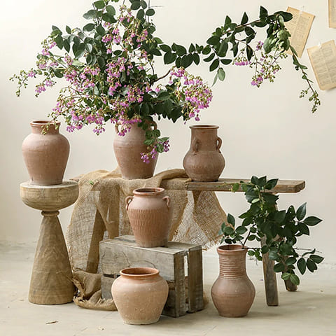 Vase Amphore Argile Rouge Vieillie, présentation tous les styles avec et sans tiges florales, sur un trépied, une caisse, un tabouret, posé au sol.