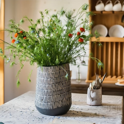 vase d'antan gris foncé strié blanc en céramique, présentation du modèle C avec fleurs sur une table.