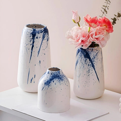 Vase Artistique Blanc et Encre Bleue en Céramique, présentation de tous les modèles avec fleurs sur une table blanche.