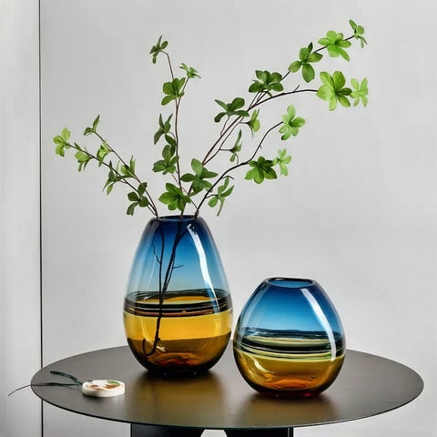 Vase Chic Couleurs Dégradées Bleu et Orangé en verre présentation des modèles S sans fleur et L avec branche sur une petite table ronde en bois.