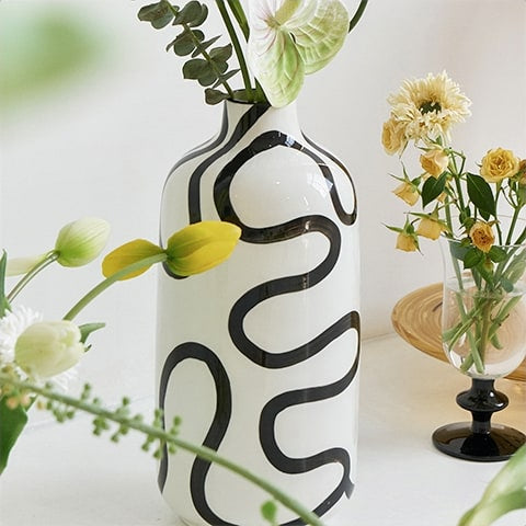 Vase Blanc Lignes Abstraites Noires Design en céramique présentation vu de près avec fleurs.
