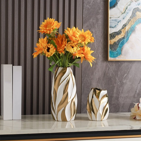 Vase blanc motif flammes dorées en céramique modèles blanc grand et petit, présentation avec bouquet de fleurs orange.