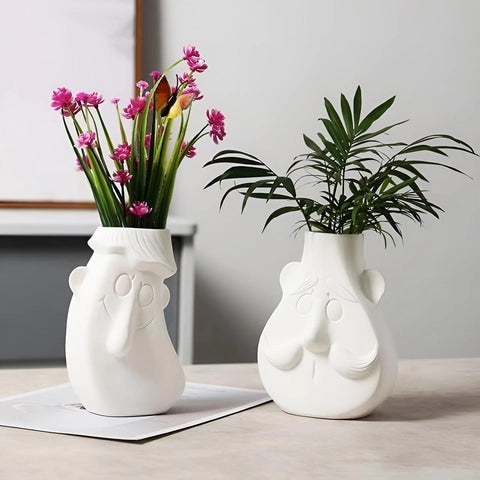 Vase Blanc Visage Monsieur Moustache en céramique présentation avec feuillages sur une table.