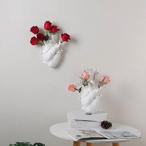Vase Cœur Humain Blanc en céramique présentation de deux modèles petit sur un mur et sur une table blanche avec roses.