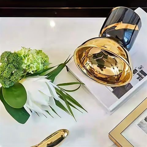 Vase Coupelle Noir et Doré en céramique présentation couché avec des fleurs à cotés sur une table.