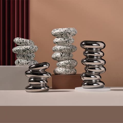 Vase Nordique galets superposés en Céramique présentation des modèles S, M, argentés, blanc et noir sur une table.