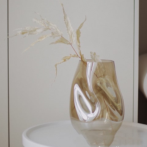 Vase Créatif Transparent Reflets Variés en verre présentation avec fleurs séchées sur une table blanche.