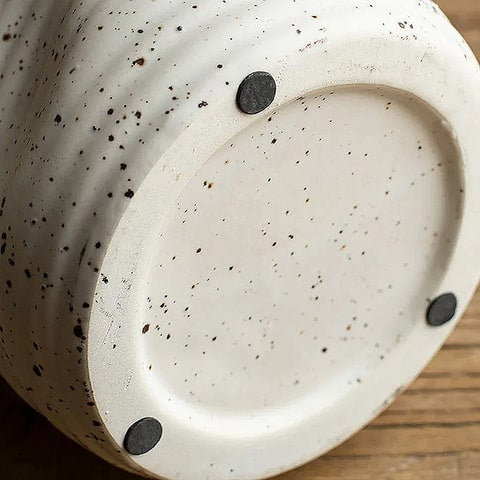 Vase cruche vintage blanc moucheté en céramique, détails du dessous des patins de protections pour les meubles.