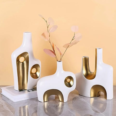 Vase de Luxe Art Abstrait Blanc et Doré en céramique présentation des modèles A, C sans fleurs et B avec tiges sur une table.