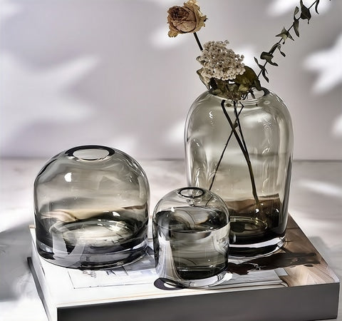 Vase décoratif gris ou blanc transparent en verre présentation des modèles Gris A, B et C sur une table avec des fleurs séchées.
