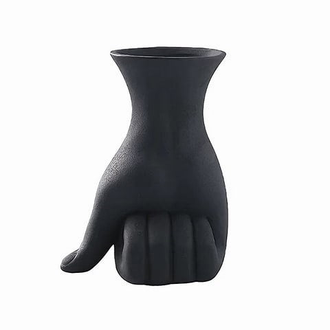 Vase design main poing fermé en céramique couleur noir sur fond blanc.
