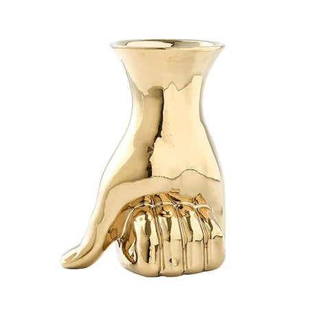Vase design main poing fermé en céramique couleur or sur fond blanc.