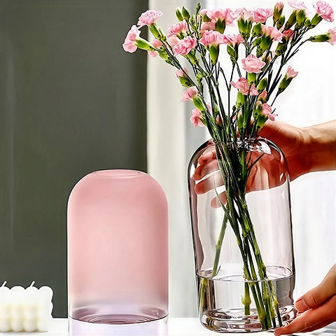 Vase Dôme Rose Décoratif en verre présentation des modèles rose poudré sans fleurs et rose avec œillets tenu en main.