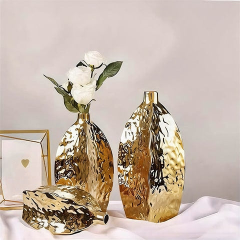Vase Doré Relief Asymétrique en céramique présentation des modèles S couché, M avec fleurs blanches et L sans fleurs sur une table.
