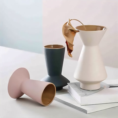 Vase Effet Givré Couleurs Variées en céramique présentation des modèles Blanc avec fleur séchée sur une pile de livres, bleu sans fleurs, rose couché sans fleurs sur une table.