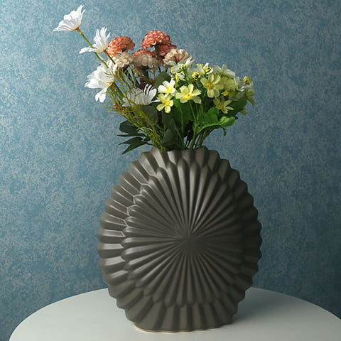 Vase Effet Rayon de Soleil en céramique présentation du modèle gris foncé avec bouquet de fleurs sur une table blanche.