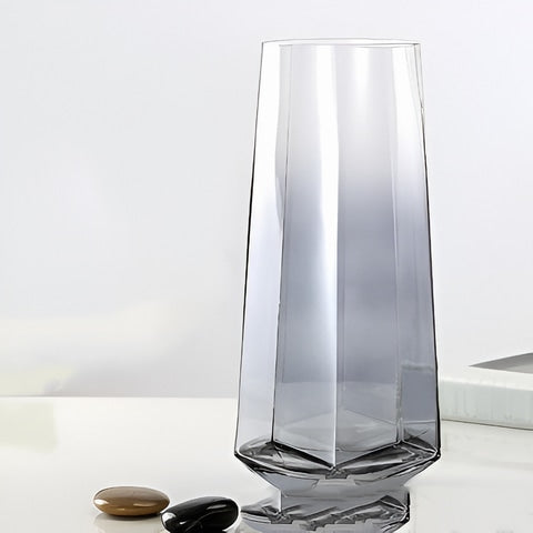Vase élégant octogonal coloré translucide en verre présentation du modèle Gris sans fleurs sur une table.