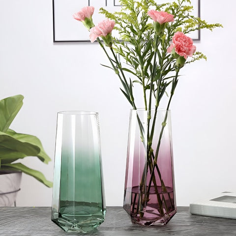 Vase élégant octogonal coloré translucide en verre présentation des modèles Vert sans fleurs et Rose avec un bouquet d'œillets, sur une table.