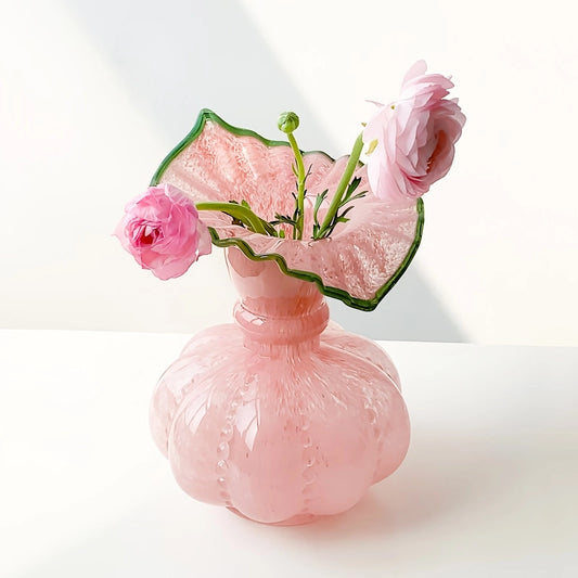 Vase Élégant Rond avec Col Forme Feuille Dentelée, présentation du modèle Rose avec fleurs sur une table blanche.