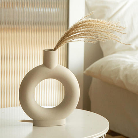 Vase en forme de donut design présentation avec Pampa sur une table blanche.