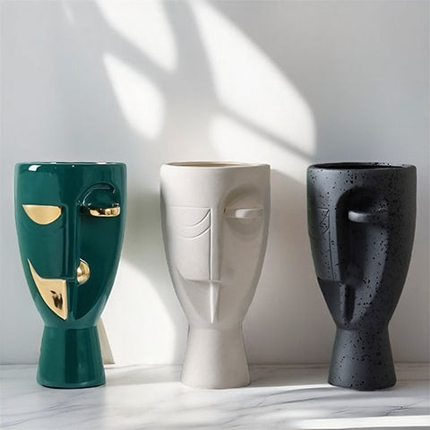 Vase en forme de visage style nordique présentation de tous les modèles sur une table en marbre.