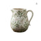 Vase d'époque motif feuillages verts en céramique modèle A forme cruche sur fond blanc.