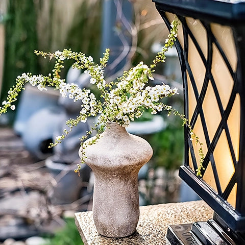 Vase Forme Champignon Vieilli en céramique présentation avec fleurs du modèle B, sur un rebord de fenêtre.