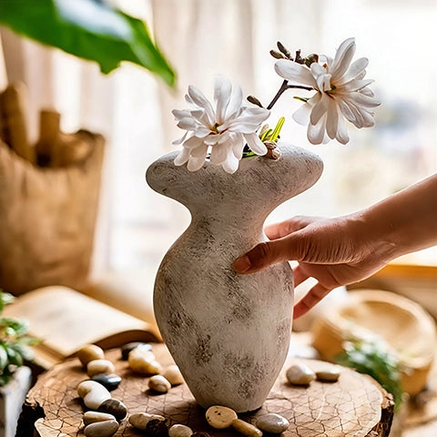 Vase forme champignon vieilli en céramique, présentation du modèle A tenu en main avec fleurs.