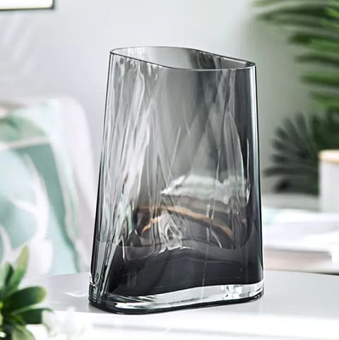 Vase géométrique translucide présentation mise en scène sans fleurs sur un meuble blanc.