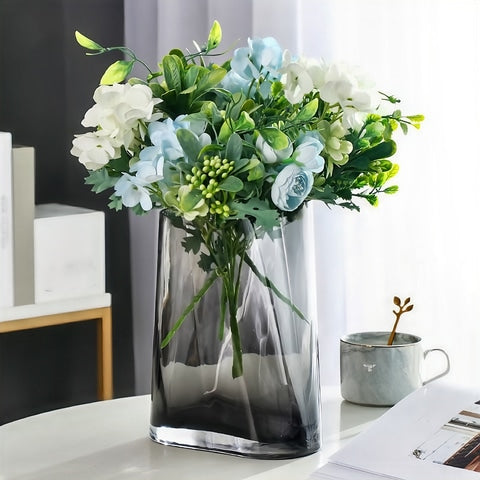 Vase géométrique translucide gris fumé seul avec bouquet de fleurs.