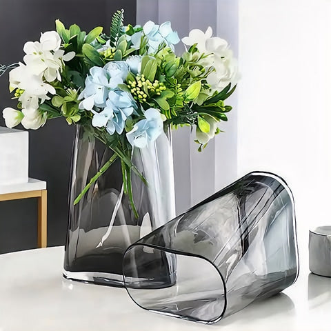 Vase Géométrique Translucide Gris Fumé en verre présentation avec bouquet de fleurs et couché sans fleurs sur une table blanche.