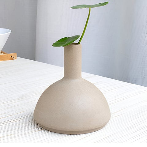 Vase en grès beige en céramique, présentation du modèle C sur une table avec plante verte.