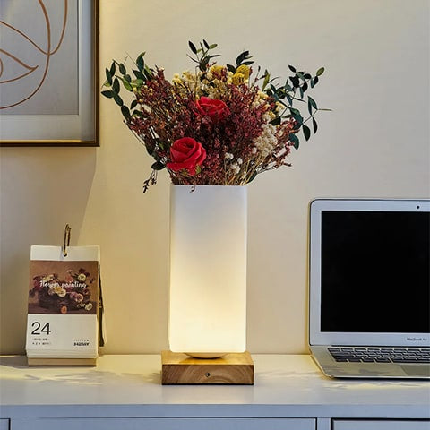 Vase lampe romantique pour fleurs séchées, présentation du modèle carré allumé, sur un bureau avec un bouquet de fleurs séchées.