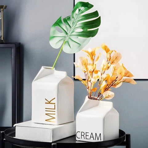 Vase Milk ou Cream en Céramique présentation des modèles milk noir et cream noir avec bouquet de fleurs, sur une table basse noir.