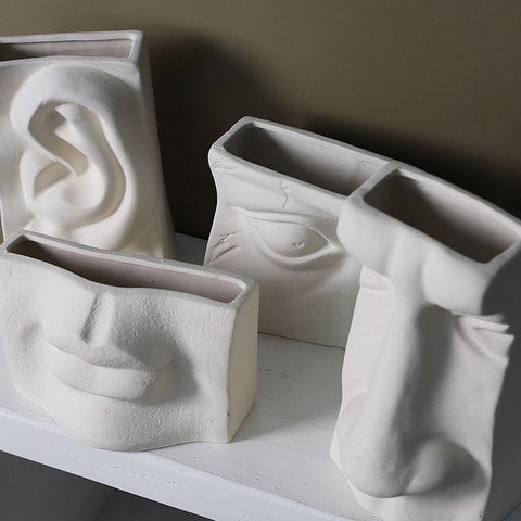Vase Minimaliste Blanc Quatre Sens Éloquent en céramique, vu du dessus présentation de tous les styles sans fleurs sur un meuble.