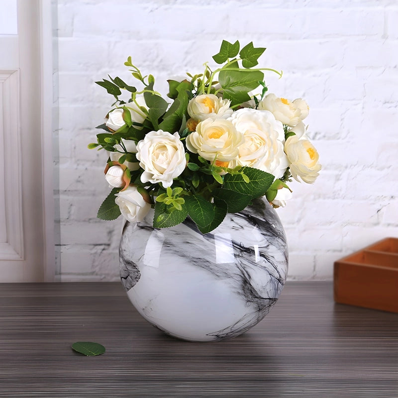 Vase Motif Marbre Rond Élégant en Verre présentation avec bouquet de fleurs blanches sur une table.