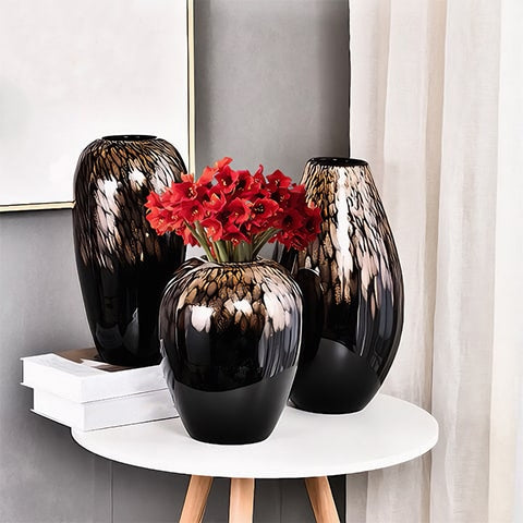 Vase noir pailleté doré en verre présentation de tous les modèles sur une table, modèle A avec bouquet de fleurs rouges.