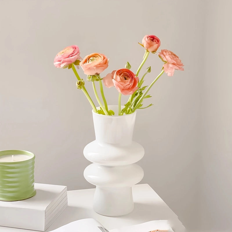 Vase Nordique Double Anneaux présentation du modèle blanc avec bouquet de fleurs roses sur un meuble blanc.