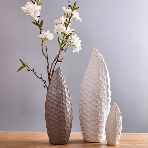 Vase nordique forme de feuille design en céramique présentation des modèles M et L blanc sur une table en bois.