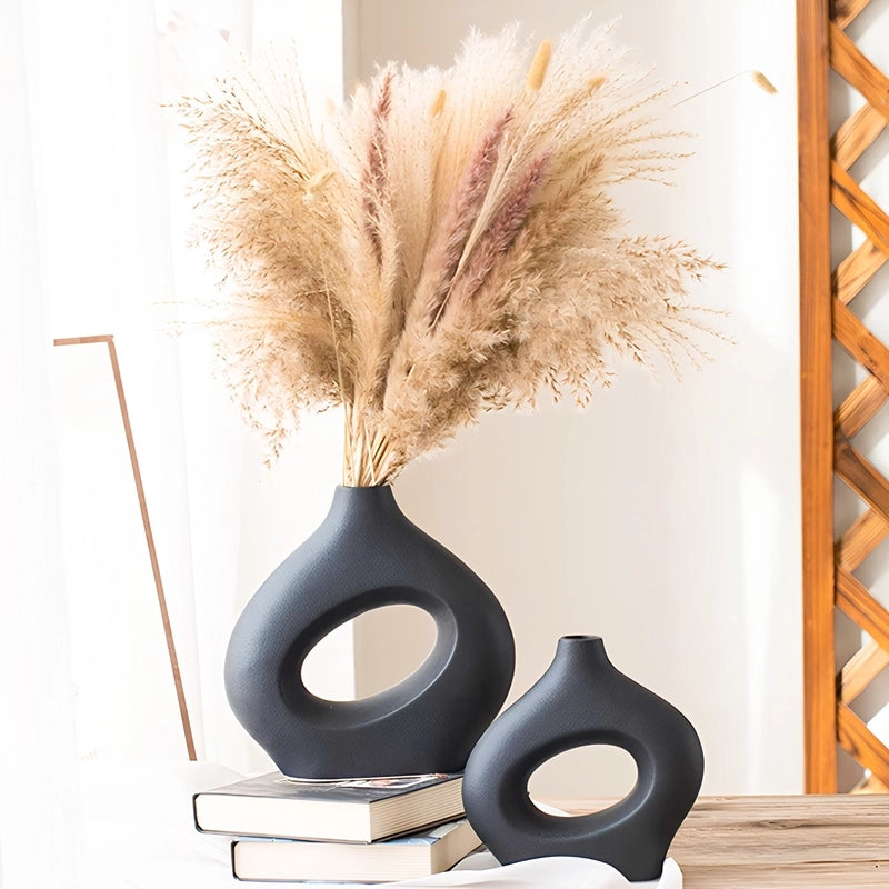 Vase Original Noir Donut présentation des modèles Grand avec fleurs séchées et petit sans fleurs sur une table en bois.