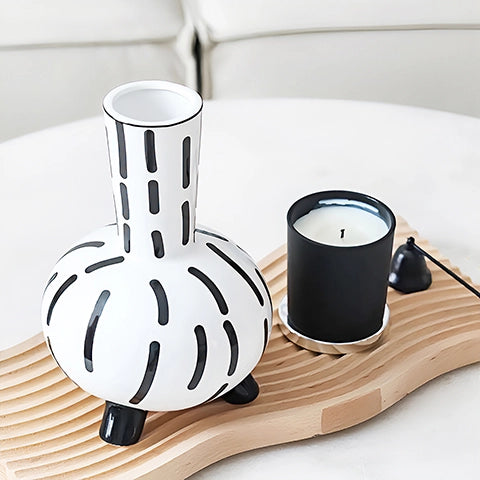 Vase original noir et blanc lignes pointillées en céramique présentation et mise en scène sans fleurs sur un plateau en bois.