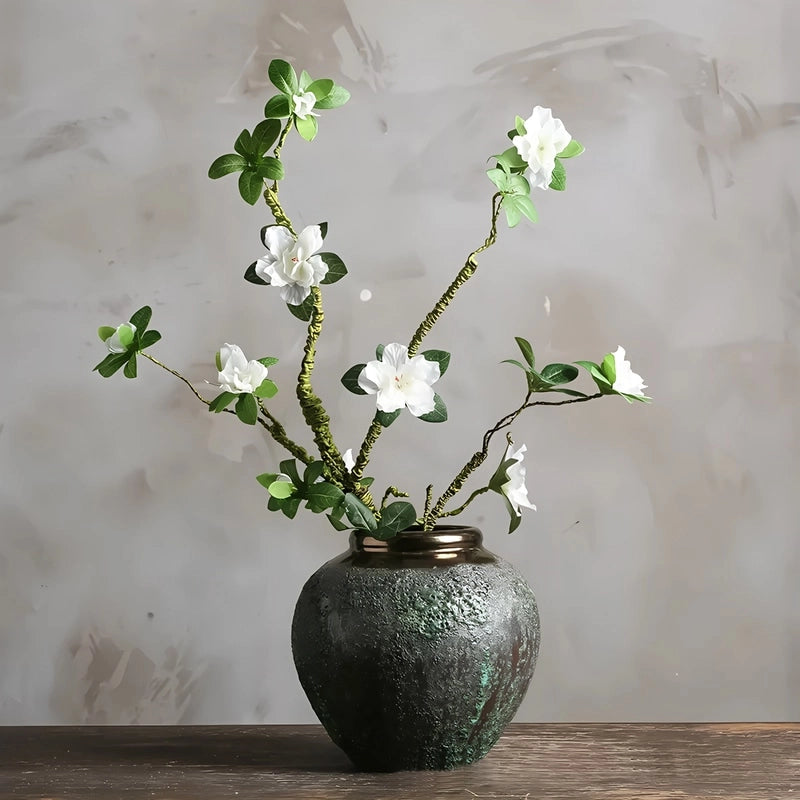 Vase Ovoïde en Grès Vieilli Finition Patinée Col Bronze présentation du modèle S avec branche fleurie sur une table en bois.