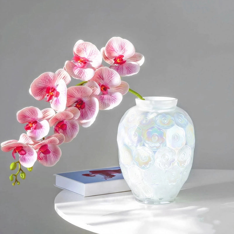 Vase Raffiné Motifs Floraux Reflets Nacrés, présentation avec hampe d'orchidées sur une table blanche.